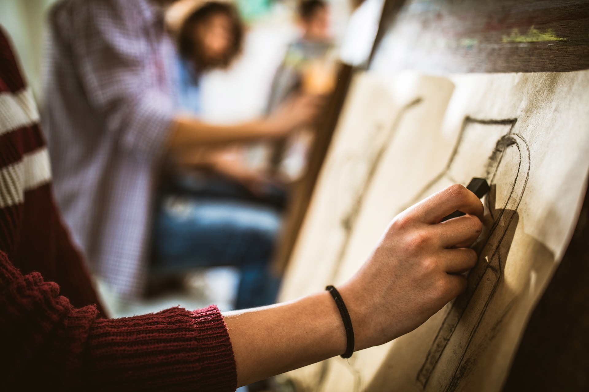 Close up of unrecognizable painter drawing on art class.